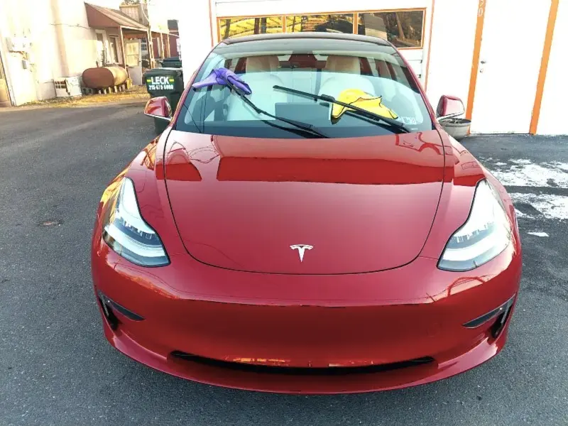 Red Tesla sedan centered — ceramic coating showcase