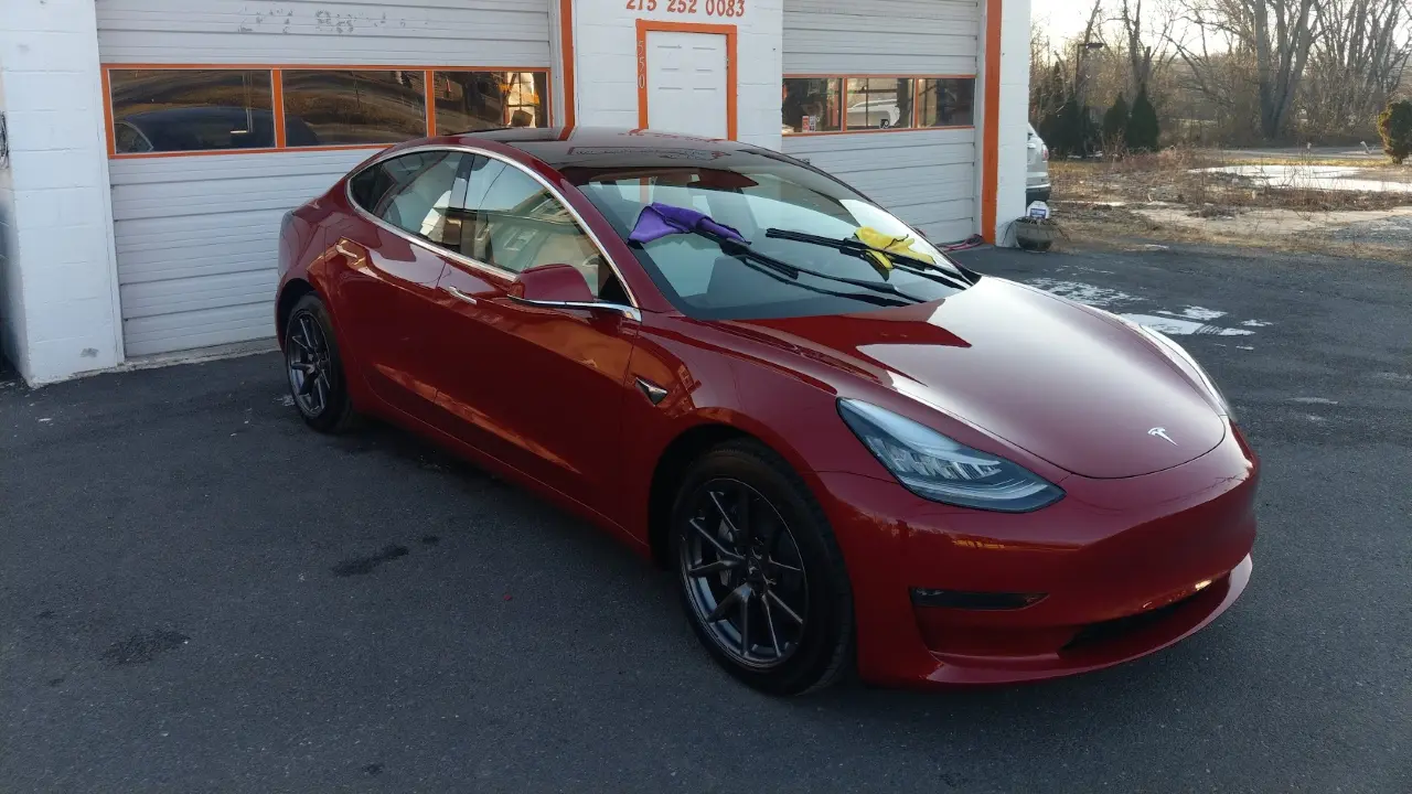 Red Tesla sedan angled left — finished ceramic coating cars