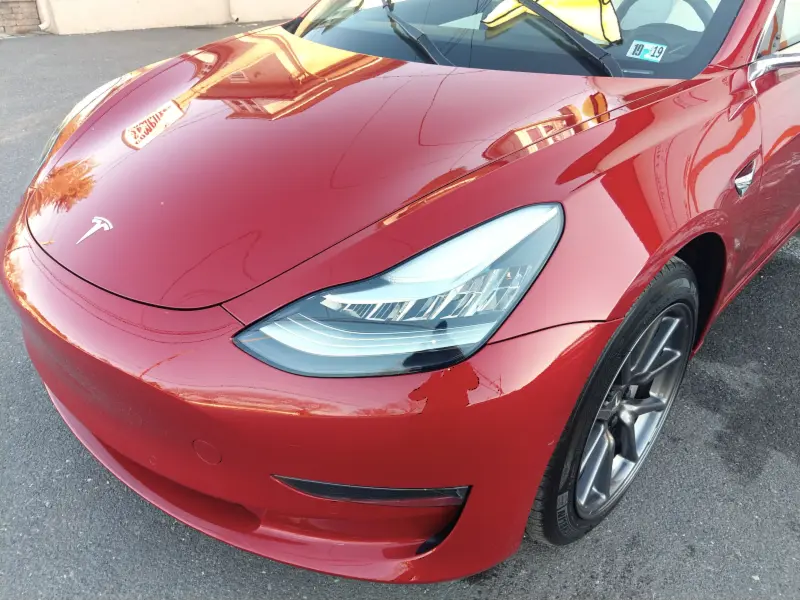 Red Tesla sedan angled right — ceramic coating car results