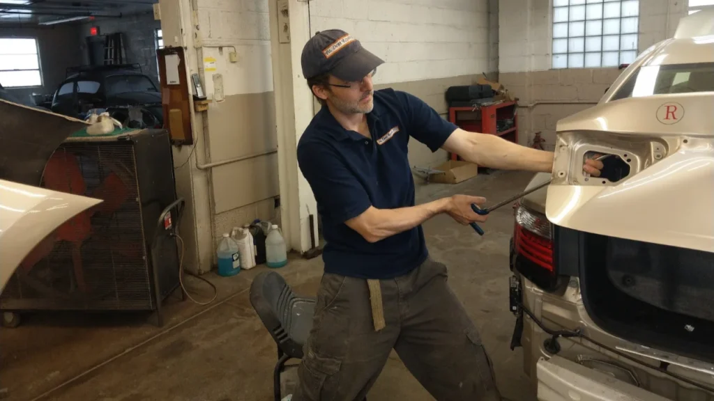 Paintless dent repair technician restoring a car panel