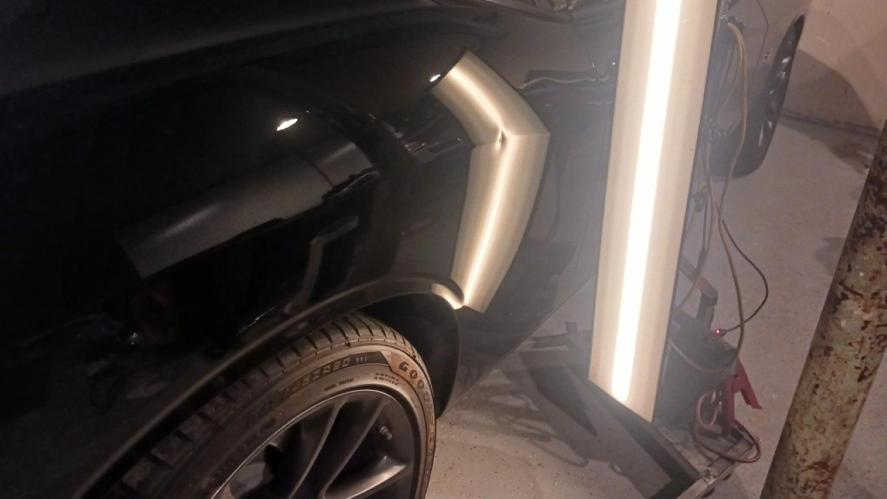 Dent on passenger quarter panel of Dodge Challenger, located on body line near wheel arch