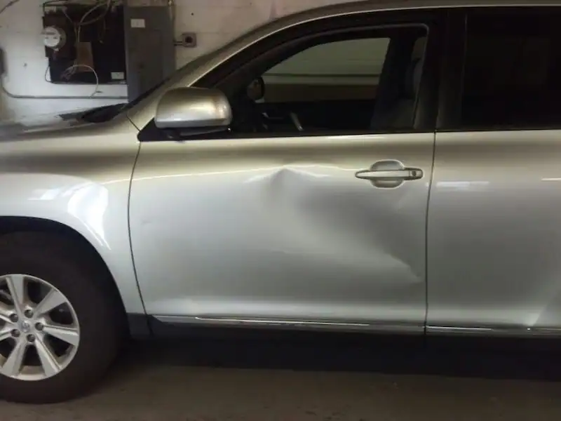 Vehicle door panel shown for paintless dent repair service.