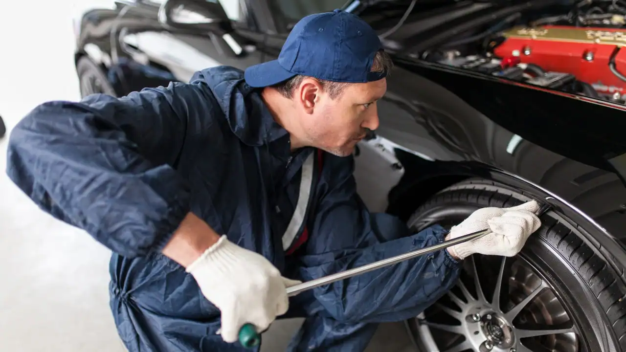 Paintless dent repair technician working on a vehicle panel.
