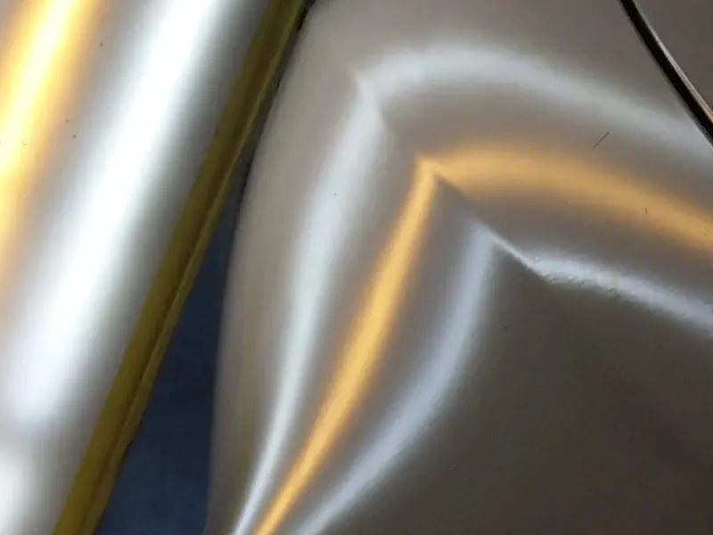 Close‑up after‑repair image of the Lexus fender from the paintless dent repair spotlight, showing a smooth, distortion‑free finish.